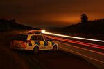 A night shot of the Irish Traffic Corps doing a speed check on a motorway. Car passing on both sides of the carrigway.