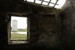 The view of Carrigafoyle Castle in Ballylongford, North Kerry, Ireland from an abandoned house across the river stream.